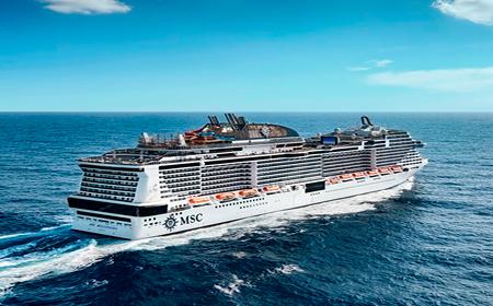 MSC cruise ship sailing across the open ocean under a clear blue sky.