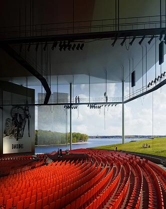 Interior of the open-air Cogeco amphitheater with curved rows of red seats overlooking a scenic lake and landscape.